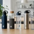 Borracce personalizzate in acciaio, alluminio, vetro e plastica allineate su un tavolo